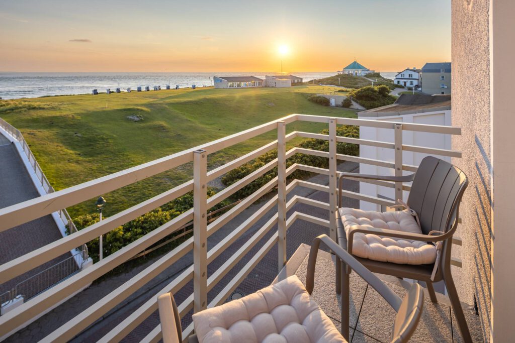 Balkon mit Meerblick im Hotel Stranddistel Norderney bei Sonnenuntergang
