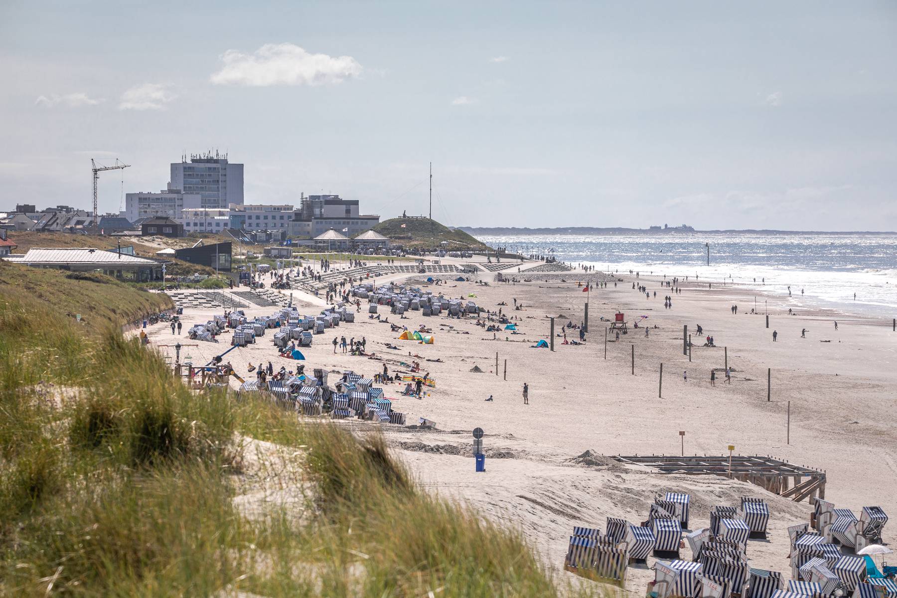 Sommer am Strand von Norderney mit Strandkörben und Blick zur Stadt