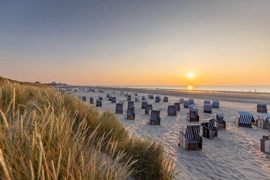 Strandkörbe im Sonnenuntergang am Strand von Norderney
