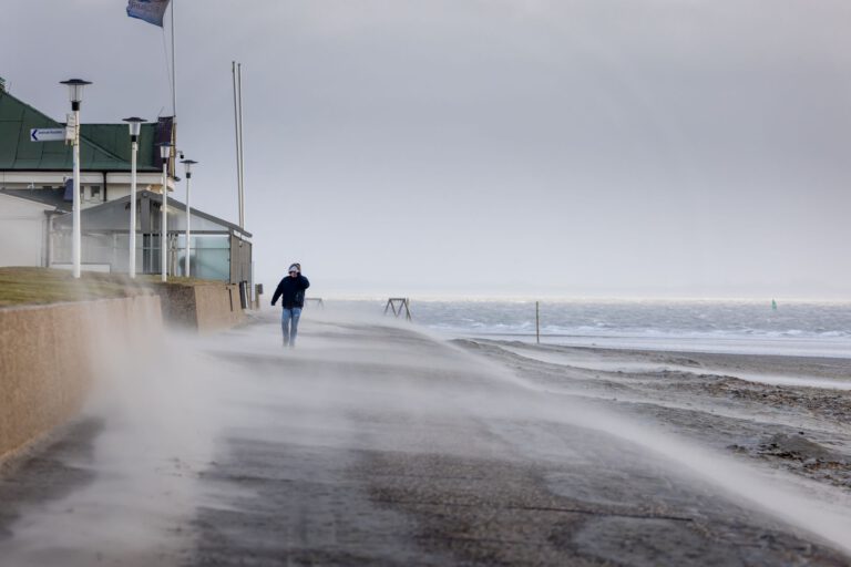 Sand weht bei Sturm über die Promenade auf Norderney